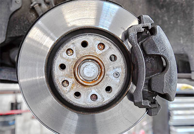 Mechaniker kontrolliert die Bremsanlage eines Autos